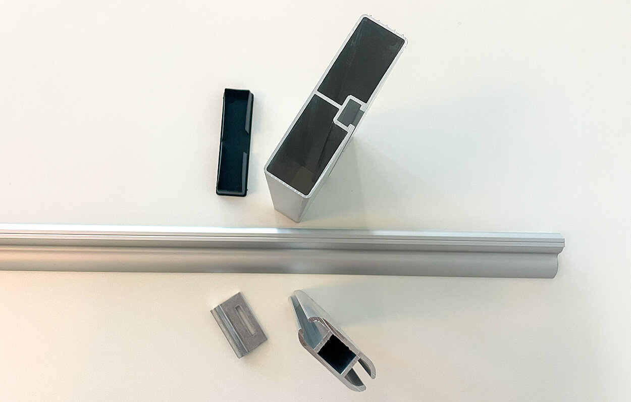 Aluminiumprofiler av typen vepaprofil med kader, underk&ouml;rningsskydd och sp&aring;rlist.